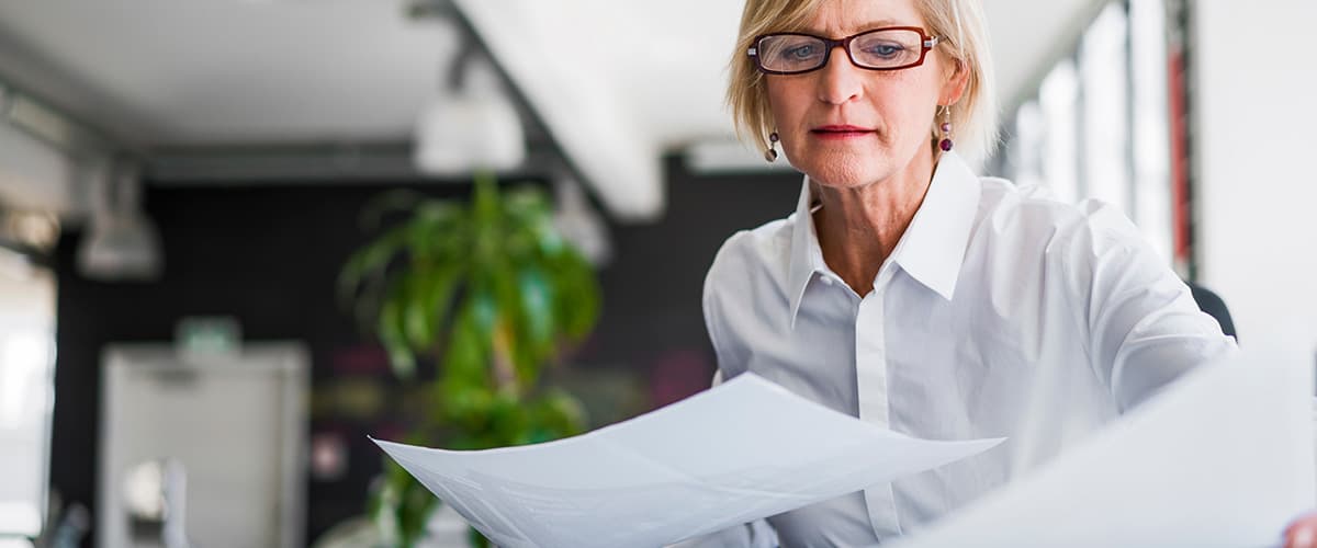 Oudere vrouw met stapel papieren